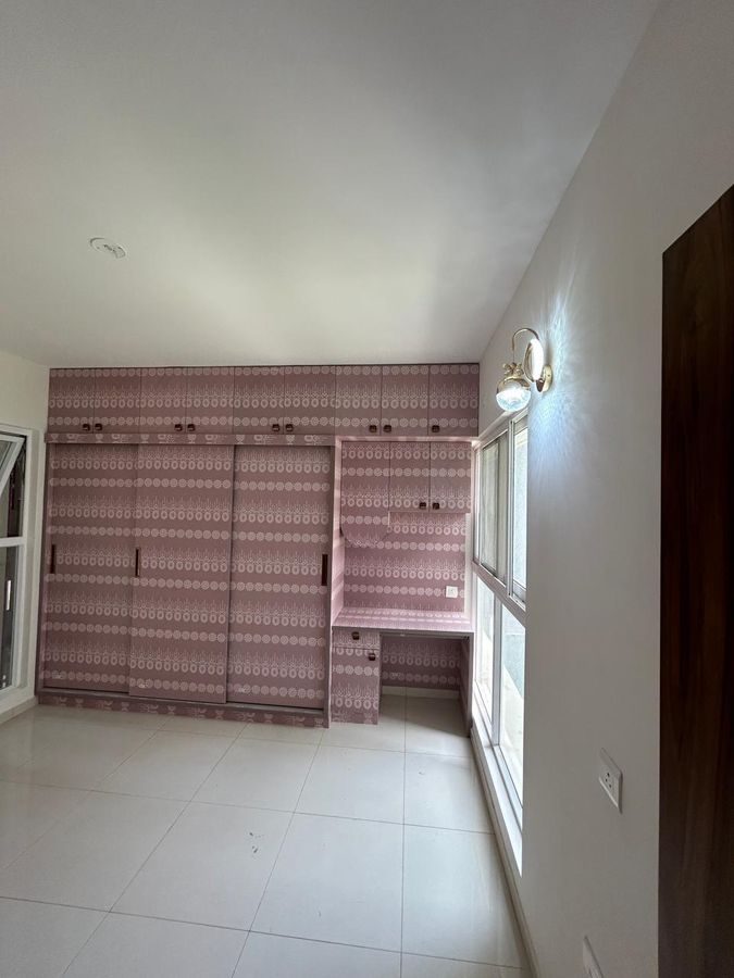 Bedroom wardrobes in a pink lace-pattern laminate with a built-in study desk