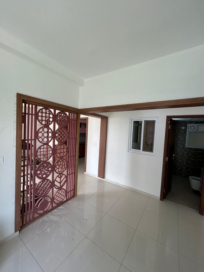 Carved jaali partition in a wooden frame between living and dining areas