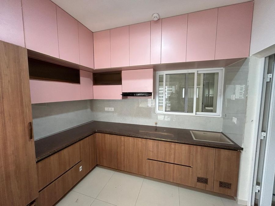 L-shaped modular kitchen with walnut-finish base cabinets and blush pink overhead cabinets